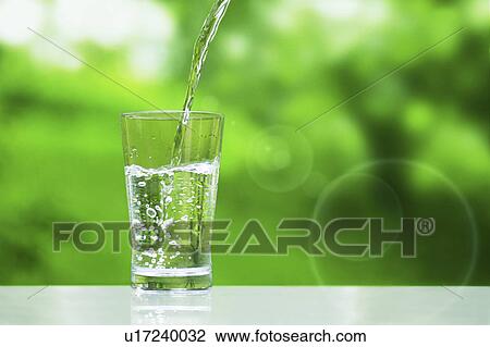 Stock Image - Water Being Poured Into Glass. Fotosearch