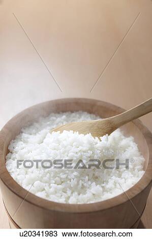 Stock Image - White rice in wooden container. Fotosearch