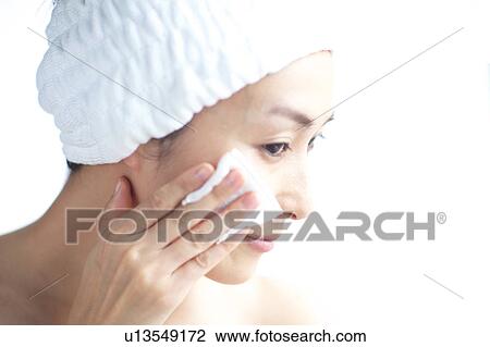 Woman cleaning her face with cotton ball View Large Photo Image Stock Image - Woman cleaning her face with cotton ball. Fotosearch