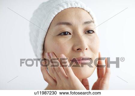 Woman massaging her face View Large Photo Image Stock Image - Woman massaging her face. Fotosearch