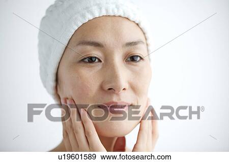 Stock Photo - Woman massaging her face. Fotosearch