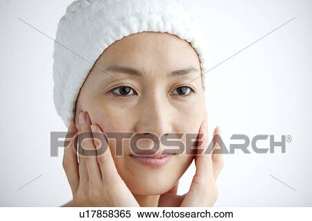 Woman massaging her face View Large Photo Image Stock Photography - Woman massaging her face. Fotosearch