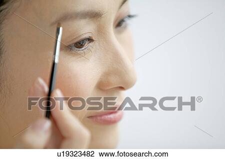 Woman putting eye make-up View Large Photo Image Stock Image - Woman putting eye make-up. Fotosearch