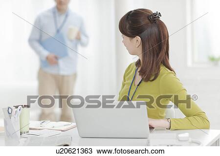 Stock Image - Woman Using Laptop and Looking Back. Fotosearch