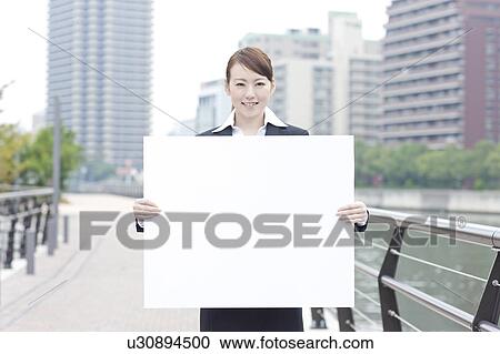 Young businesswoman holding a blank board View Large Photo Image Stock Image - Young businesswoman holding a blank board. Fotosearch