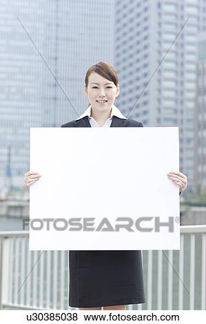 Young businesswoman holding a blank board View Large Photo Image Stock Photo - Young businesswoman holding a blank board. Fotosearch