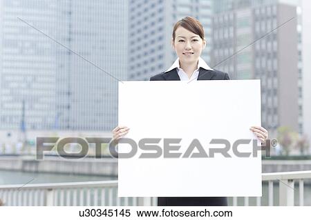 Stock Photography - Young businesswoman holding a blank board. Fotosearch