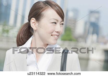 Stock Image - Young businesswoman looking away. Fotosearch