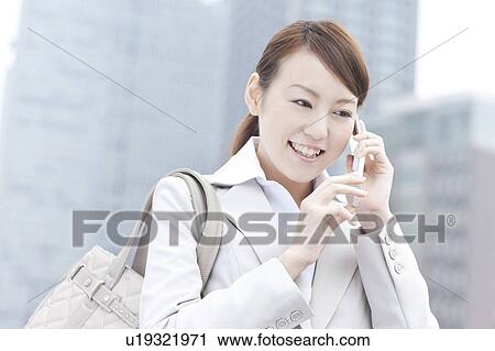 Stock Image - Young businesswoman on cell phone. Fotosearch