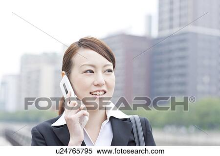 Stock Photography - Young businesswoman on cell phone. Fotosearch