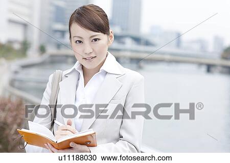 Young businesswoman with a diary View Large Photo Image Stock Image - Young businesswoman with a diary. Fotosearch