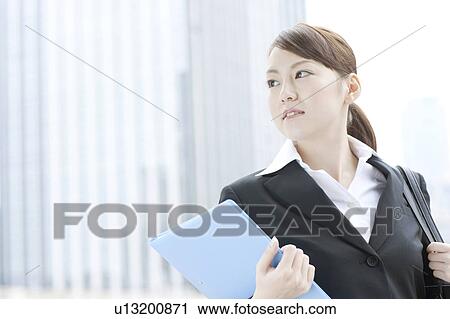 Stock Image - Young businesswoman with a file. Fotosearch