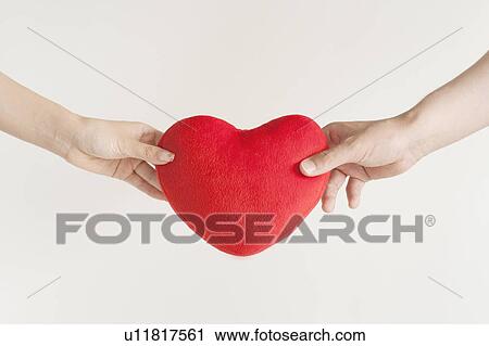 Stock Image - Young couple holding a heart. Fotosearch