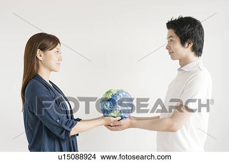 Young couple holding globe View Large Photo Image Picture - Young couple holding globe. Fotosearch