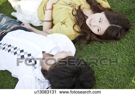 Young couple relaxing on grass View Large Photo Image Stock Image - Young couple relaxing on grass. Fotosearch