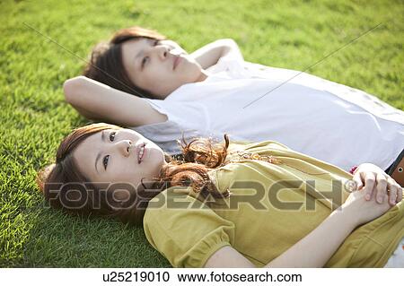 Young couple relaxing on grass View Large Photo Image Stock Image - Young couple relaxing on grass. Fotosearch