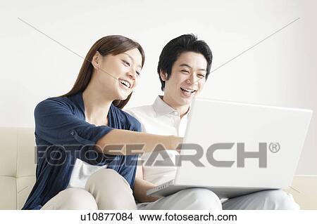 Picture - Young couple using laptop. Fotosearch