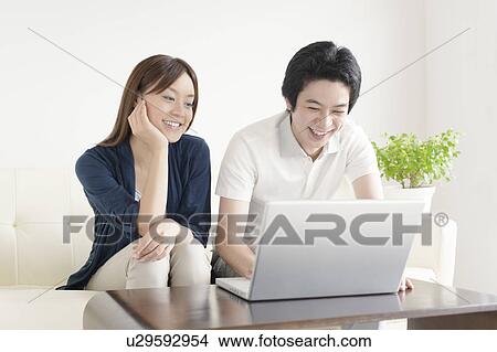 Picture - Young couple using laptop. Fotosearch