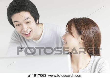 Stock Image - Young couple using laptop. Fotosearch