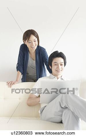 Stock Image - Young couple using laptop. Fotosearch