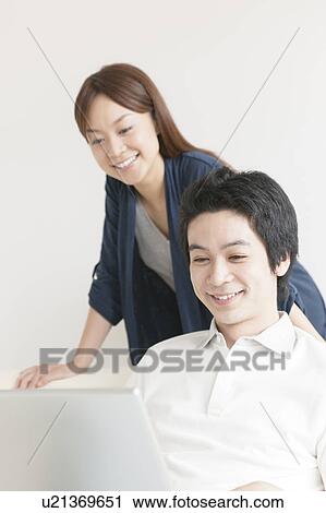 Stock Image - Young couple using laptop. Fotosearch
