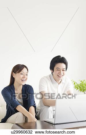Stock Image - Young couple using laptop. Fotosearch
