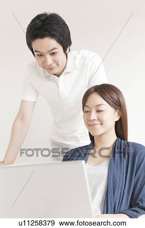 Stock Photo - Young couple using laptop. Fotosearch