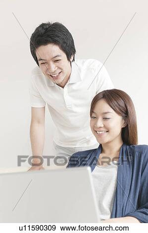 Stock Photo - Young couple using laptop. Fotosearch