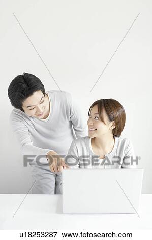 Young couple using laptop View Large Photo Image Stock Photo - Young couple using laptop. Fotosearch