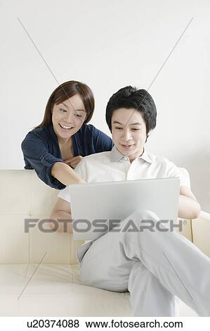 Young couple using laptop View Large Photo Image Stock Photo - Young couple using laptop. Fotosearch