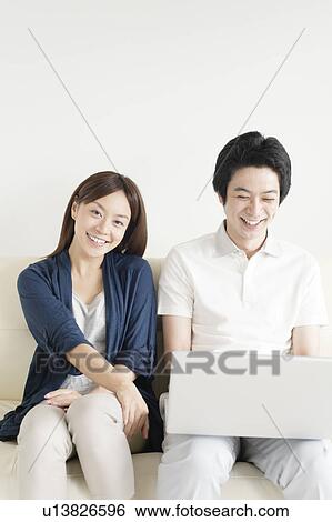 Stock Photograph - Young couple using laptop. Fotosearch