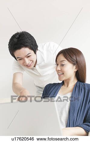 Stock Photograph - Young couple using laptop. Fotosearch