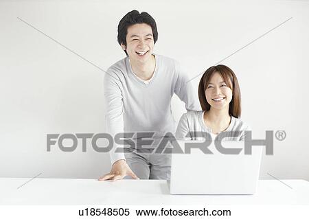 Stock Photography - Young couple using laptop. Fotosearch