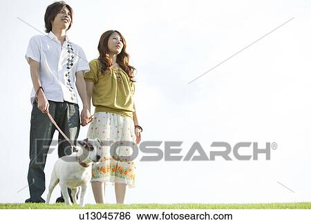 Stock Photograph - Young couple with a dog. Fotosearch