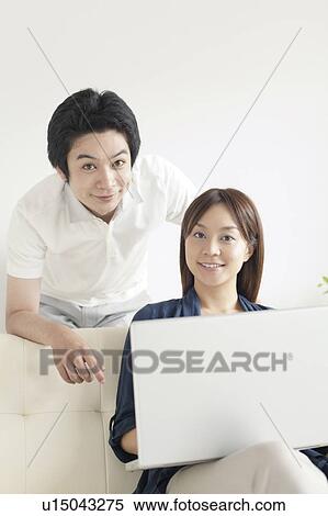 Young couple with laptop looking at camera View Large Photo Image Stock Photography - Young couple with laptop looking at camera. Fotosearch