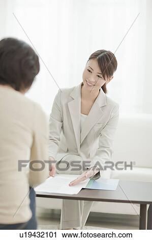Stock Image - Young Female Consultant with Client. Fotosearch