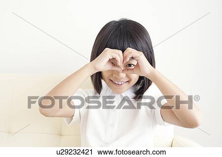 Stock Image - Young Girl Forming Binoculars With Fingers. Fotosearch