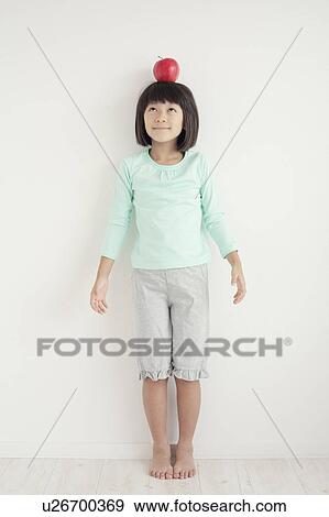 Young Girl Holding Apple on Her Head View Large Photo Image Stock Photo - Young Girl Holding Apple on Her Head. Fotosearch