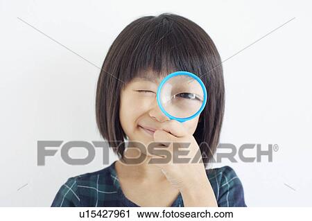 Stock Image - Young Girl Looking Through Magnifying Glass. Fotosearch