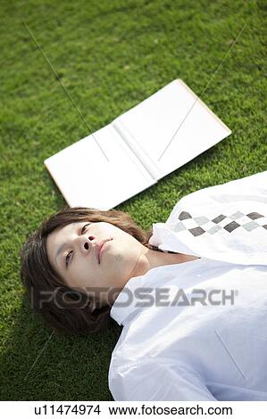 Young man lying on back View Large Photo Image Picture - Young man lying on back. Fotosearch