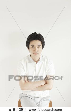 Young man sitting and looking at camera View Large Photo Image Stock Image - Young man sitting and looking at camera. Fotosearch