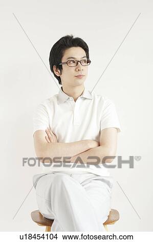 Picture - Young man sitting and looking away. Fotosearch