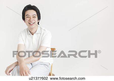 Young man sitting and looking away View Large Photo Image Stock Image - Young man sitting and looking away. Fotosearch