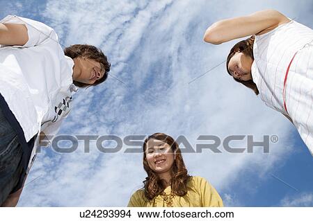Picture - Young people standing and smiling outdoors. Fotosearch