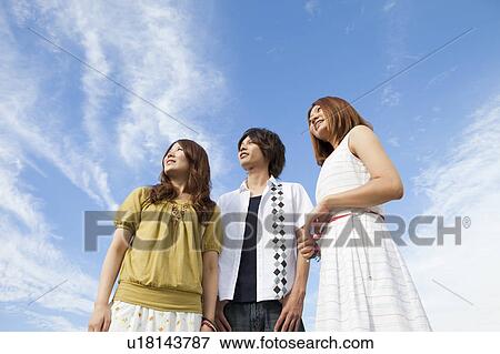 Stock Photo - Young people standing and smiling outdoors. Fotosearch