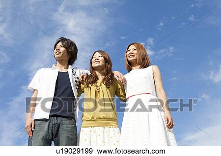 Stock Photo - Young people standing and smiling outdoors. Fotosearch