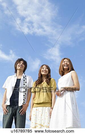 Stock Photography - Young people standing and smiling outdoors. Fotosearch