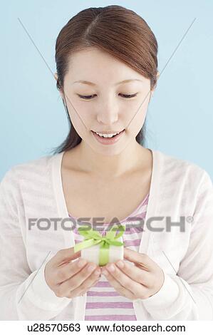 Stock Image - Young Woman Giving Gift. Fotosearch