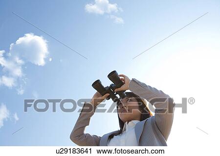 Young woman holding binoculars View Large Photo Image Stock Image - Young woman holding binoculars. Fotosearch