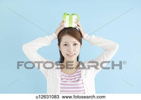 Young Woman Holding Gift On Top Of Her Head View Large Photo Image Stock Image - Young Woman Holding Gift On Top Of Her Head. Fotosearch